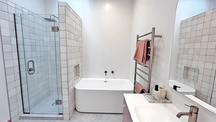 Finished bathroom renovation with a tiled shower and freestanding bath